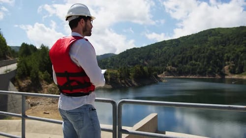 Engineer Checks Water Flow of an Artificial Dam on the Mountains