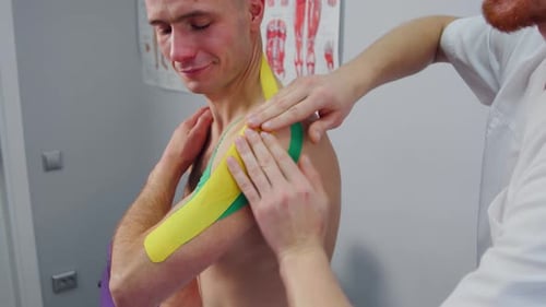 Man Receives Kinesiology Tape Treatment for Shoulder Pain