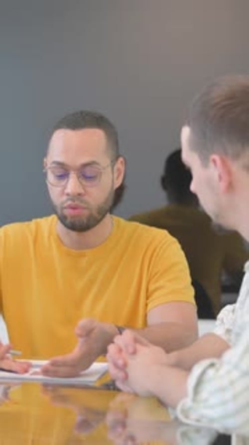 Men Discussing Graphs at Office Meeting