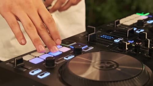 Un DJ reproduce música con un controlador de mezclas de DJ en una fiesta nocturna