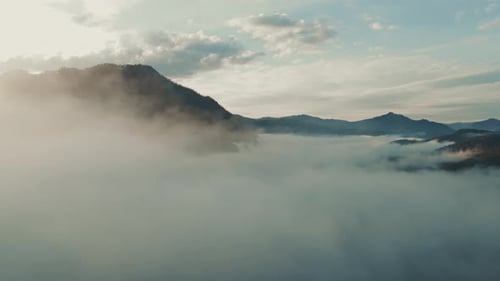 Morning Mist Envelops Mountain Range at Sunrise in Serene Landscape