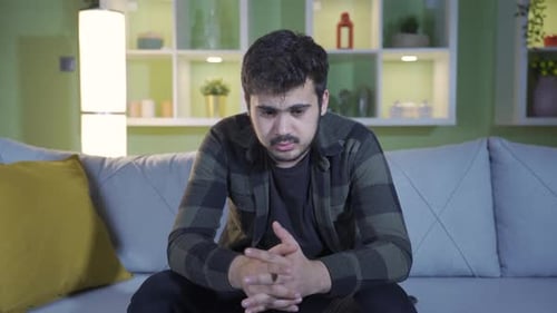 Young Man Using Phone on Couch