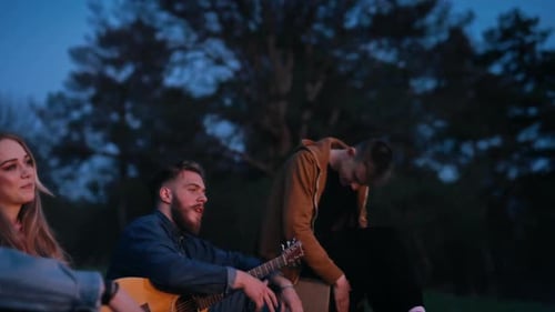 Friends Gather Around Campfire at Night