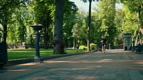 Woman Jogging in Urban Park on Sunny Day