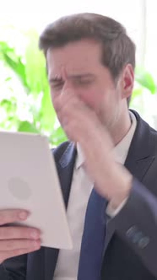 Upset Young Businessman Reacting to Loss on Tablet in Office, vertical video