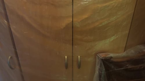 L'armoire de rangement en bois sophistiquée dotée d'élégantes poignées métalliques met en valeur des objets exceptionnels