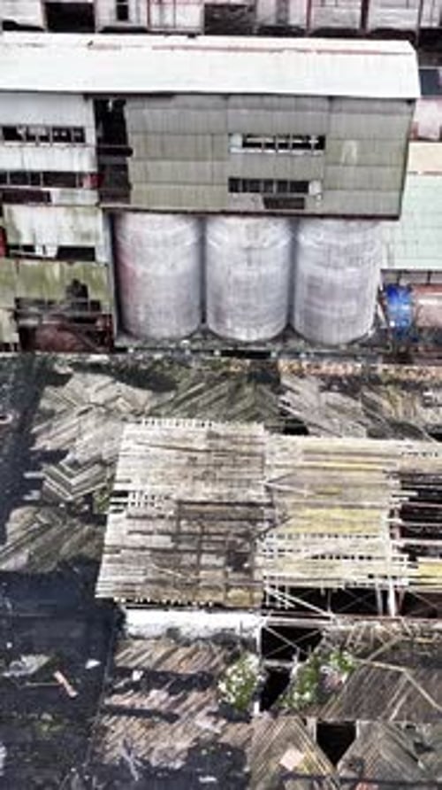 Warehouses of an old plant. Aerial perspective on the wrecked roof of a long empty warehouse