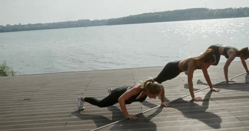 Slim Ladies in Sportswear Jumping on Step and Doing Push Ups During Fitness Training on Embankment