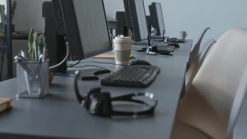 Microphone Headset and Computer on Grey Work Desk of Call Centre Operator