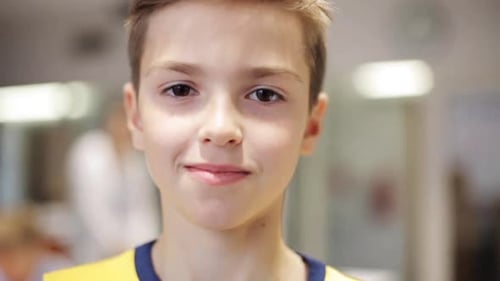 Smiling boy with light brown hair close up