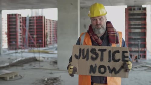 Construction Worker Protests for Justice Holding Sign