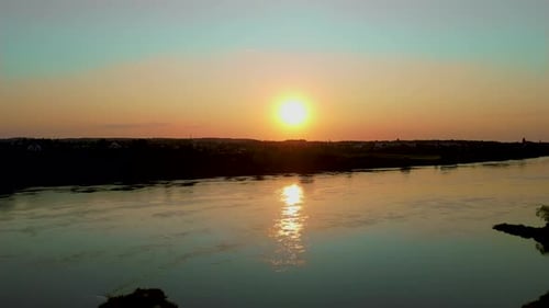 Cinematic Sundown Over River with Sun Reflection in Water