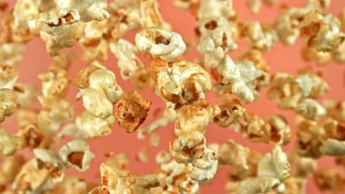 Popcorn pieces floating with a pink background