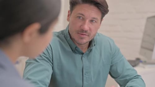 Close up of Middle Aged Man Talking with Teammate