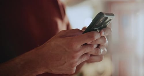 Man's Hands Using Mobile Phone in Indoor Setting