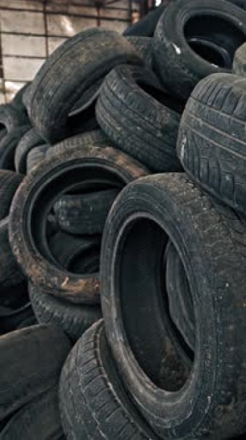 Lot of old tires from cars. Second hand tyres stacked up at old dump