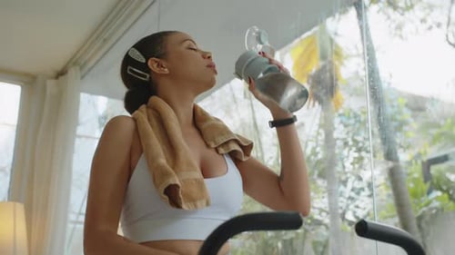 Woman Drinks Water After Working Out at Home