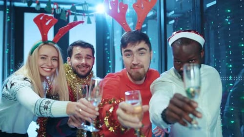 Young Adults Celebrate Christmas with Champagne at Workplace