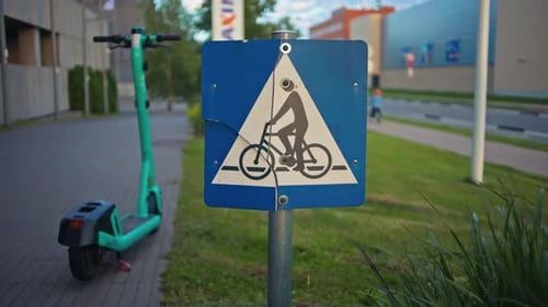 This is a Bicycle Path Sign Alongside an EScooter Found in a Bustling Urban Setting of a Modern City