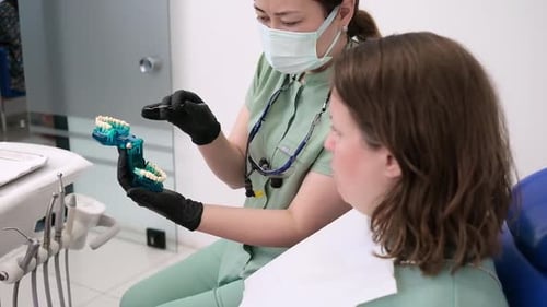 Professional Dentist Checking Patients Teeth and Explaining Procedures During at Dentist's Office