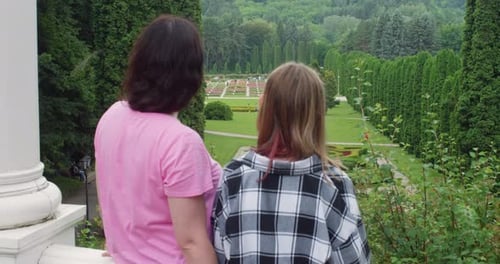 Mother and Daughter Admiring Formal Garden Landscape From Terrace in Park Together