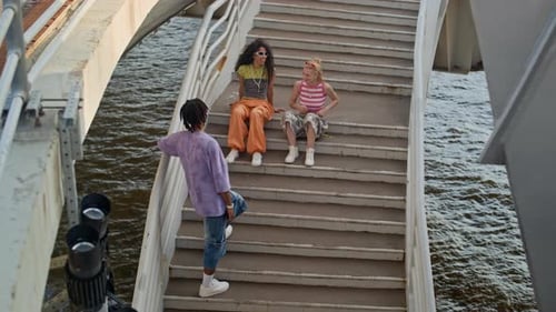 Carefree Gen Z Multiethnic Friends Hanging Out Together on Bridge in Summer
