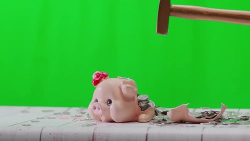 Breaking the piggy bank with a hammer, close-up, chroma key