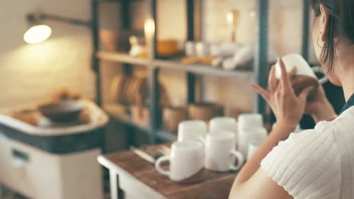 Pottery, workshop and woman check cup, ceramic design or mug for quality assurance