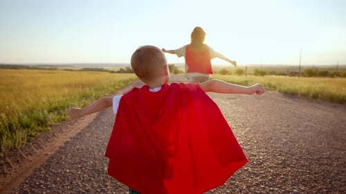 Two Running Children in Field Under Sunlight Brother and Sister Put Homemade Superheroes Costumes
