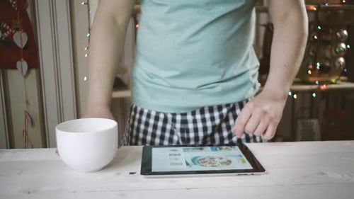 Man Using Tablet in Kitchen at Home