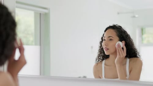 Young Woman Cleans Face in Bright Bathroom