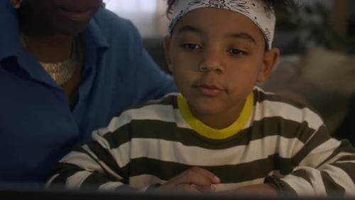 Boy Using Laptop with Adult in Living Room