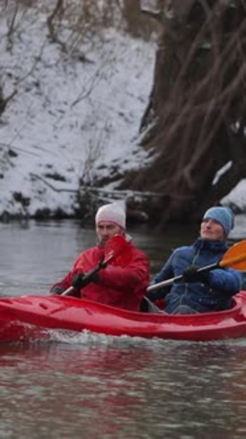 Vertical Video Kayaking in Winter Wonderland with Friends on a Serene River
