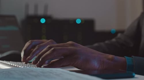 Hands Typing on Keyboard in Dark Server Room