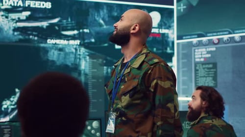 Man Gesturing at Large Monitor in Control Center