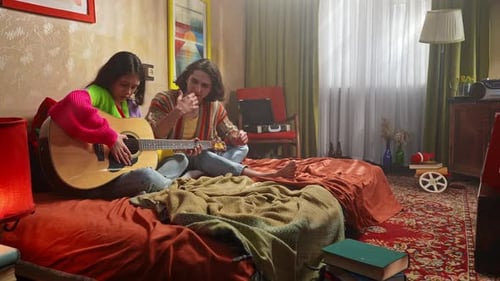 Young People Enjoying Music and Relaxing in Cozy Bedroom Setting