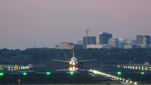Passenger Airplane Accelerating Down the Runway and Taking Off at Sunset