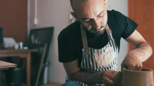 Man, potter and pottery studio with worker, craftsmanship and clay in ceramic workshop