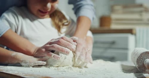 Uma mãe se diverte enquanto mostra como cozinhar para a filha vestida de chef na cozinha. Conce