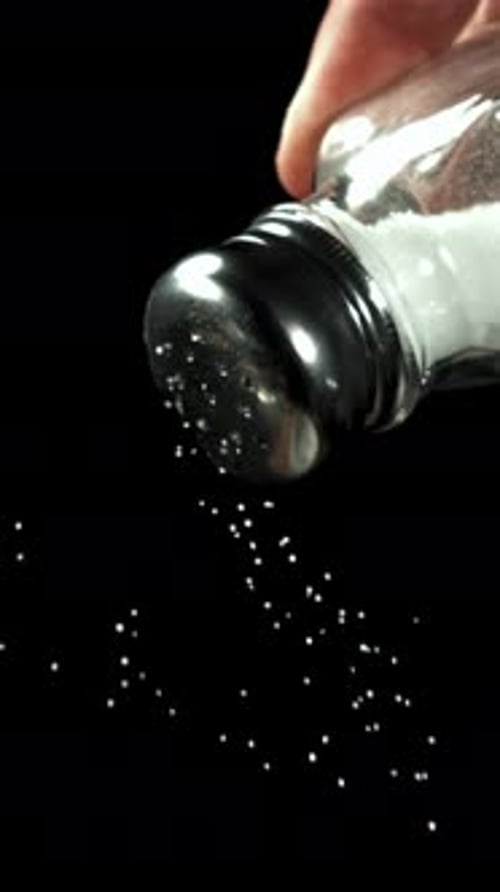 Salt Falls From a Salt Shaker on a Black Background Filmed on a Highspeed Camera at 1000 Fps