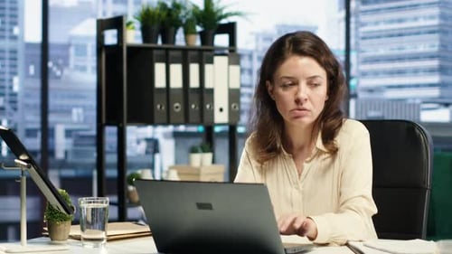 Professional Woman Working at Laptop in Modern Office