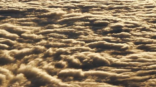 Enjoy the Breathtaking View of Golden Sunset Clouds From Above in This Stunning Aerial Landscape