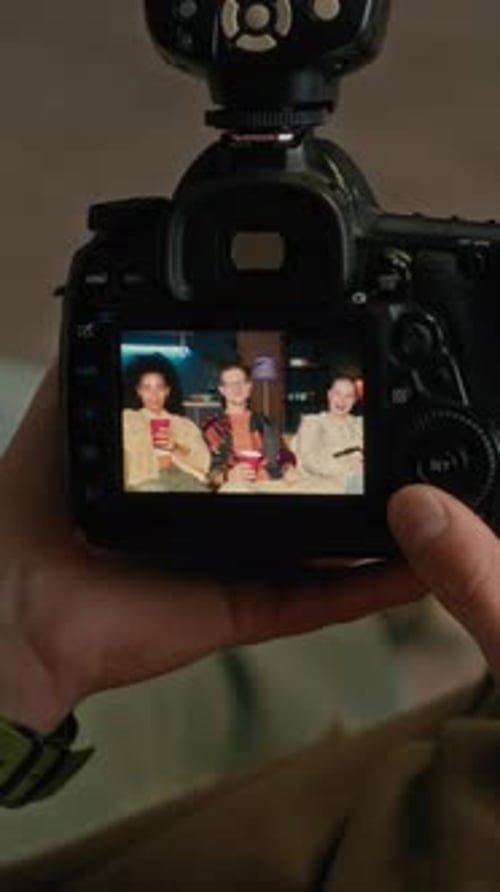 Vertical of Photographer Viewing Group Photo on Camera Screen