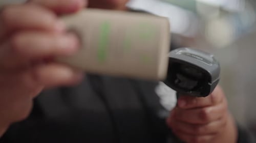 Plan flou partiel d'une personne scannant un produit