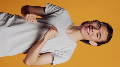 Vídeo vertical de homem asiático mostrando movimentos de dança legais na câmera