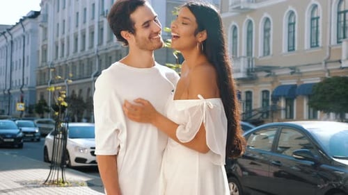 Young Couple Embraces and Kisses on City Street