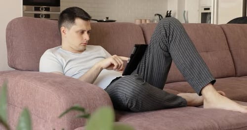 Man Relaxing Indoors with Tablet at Home