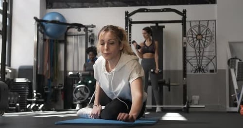 Fitness Woman Doing Stretching Exercises After Working Out at the Gym