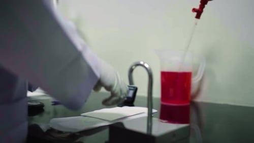 Primer plano de la libreta de una niña haciendo pruebas de laboratorio en papel