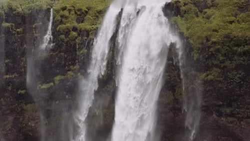 Majestic Waterfall Cascading Over Tropical Rock Face